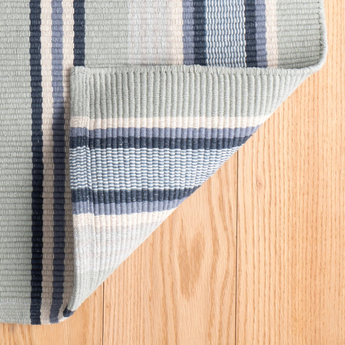 Barbados Stripe Handwoven Cotton Rug - Blue, styled in a room - Starboard Lane