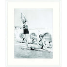 Vintage black and white photograph of two swimmers playing at the edge of a pool
